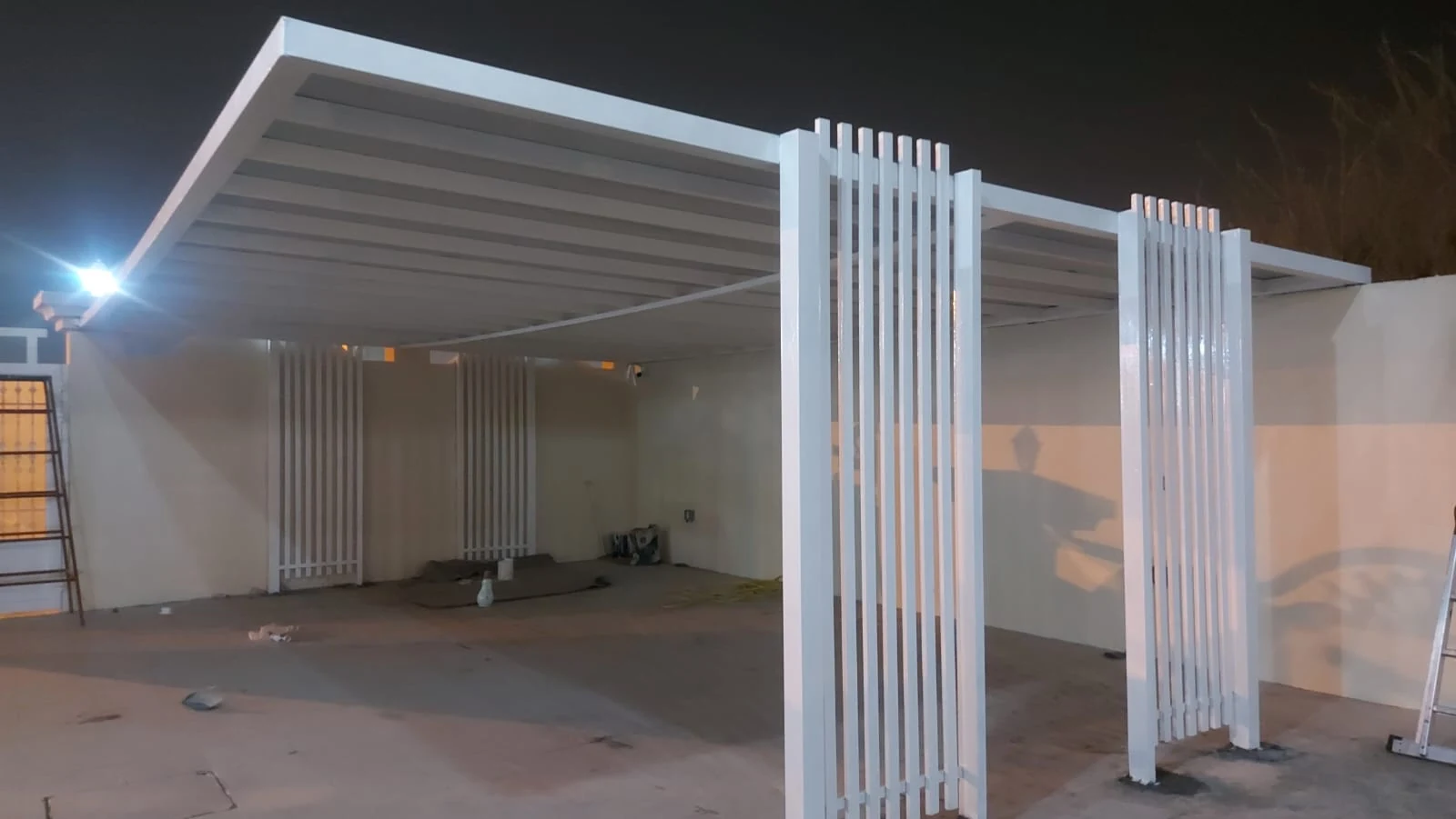 Metal parking shelter at night