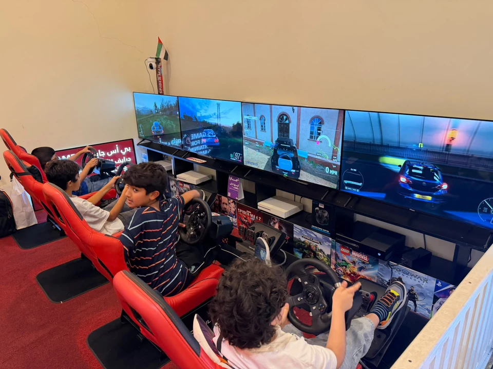Young players using steering wheels at the PS Game Drive racing stations